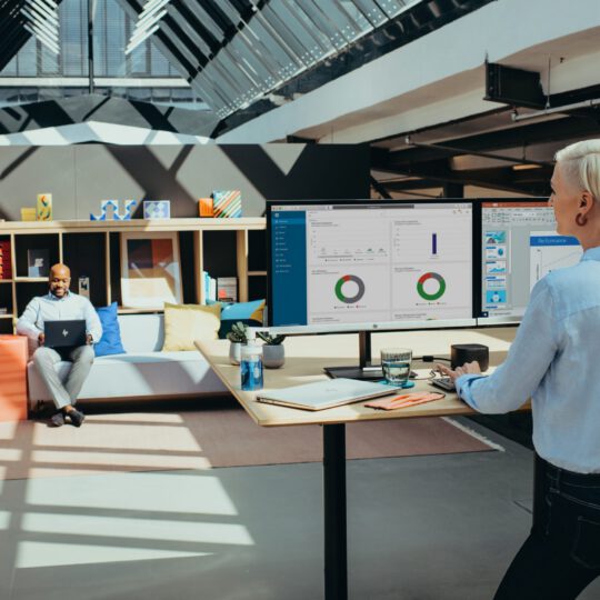 Deux collaborateurs dans un espace de travail lumineux et moderne, favorisant la productivité et le bien-être au bureau.